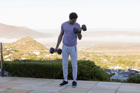 Man Exercising Outdoors with Weights in Tranquil Setting
