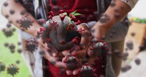 Parent and child hands cupping spiked virus globe on porch, conveying protection and risk
