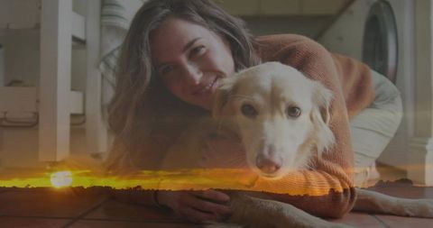 Woman hugging light-colored dog on tiled floor with sunset glow overlay cozy indoor moment