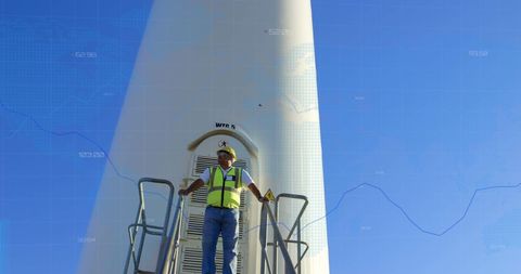 Engineer Overseeing Wind Turbine with Financial Data Overlay