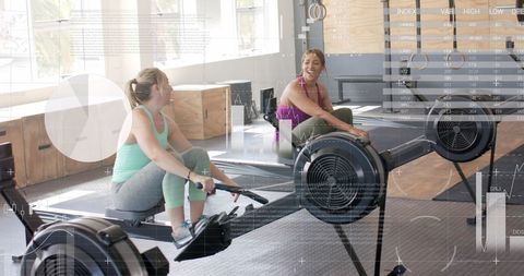 Women exercising on rowing machines with digital interface overlay