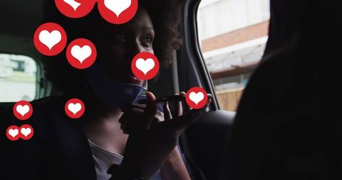 African American Woman Using Smartphone in Car with Social Media Hearts