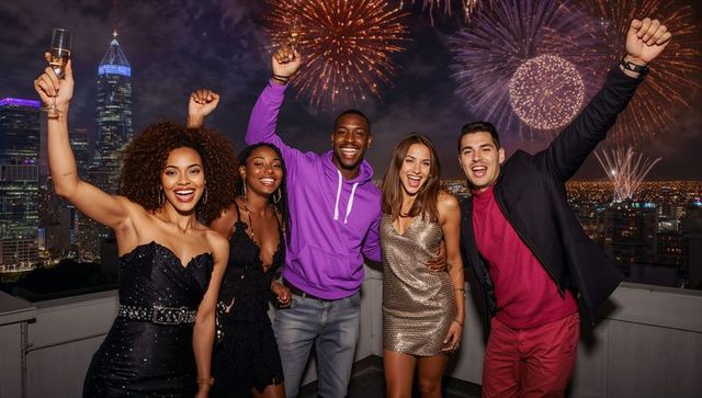 Rooftop friends celebrating with champagne flutes under city fireworks nightlife skyline