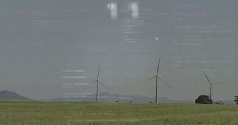 Wind Turbines Generating Renewable Energy Over a Green Field Landscape