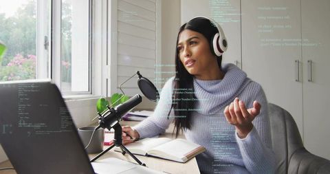 Woman recording podcast at home office with headset and condenser microphone near window