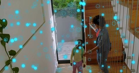 Parent unlocking smart front door while child carrying green backpack entering modern foyer