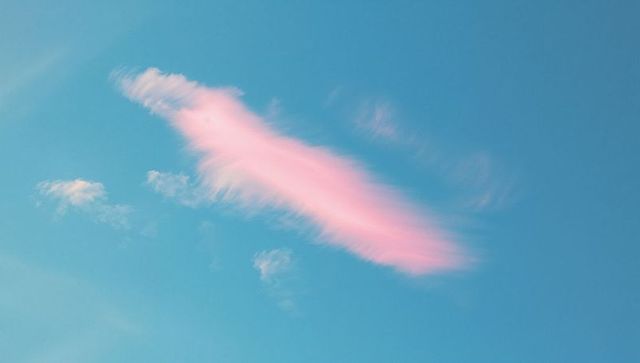 Dreamy Pink Cloud Drift Against Clear Blue Sky
