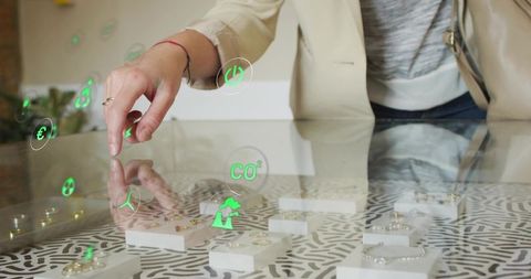 Woman reaching ring on glass display with green ar icons showcasing augmented smart retail