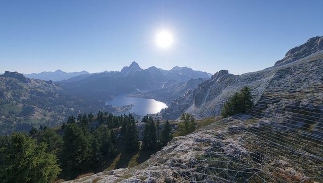 Surveying alpine peak and glacial lake reflecting sun with wireframe terrain mesh overlay