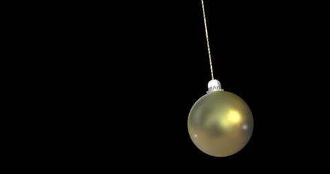 Golden Ornament Hanging on Braided Cord with Dark Background