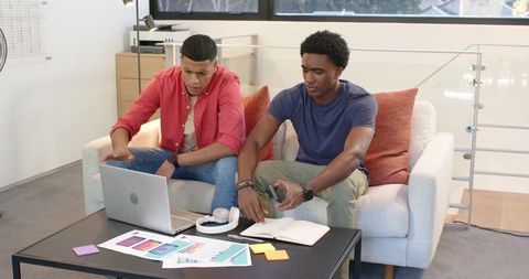 Creative team collaboration using laptop and color swatches in modern office