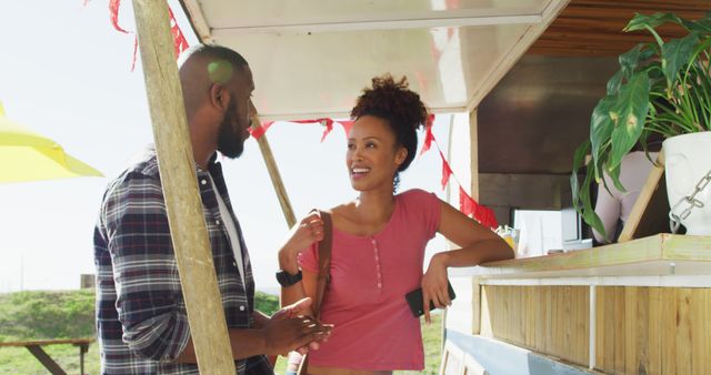 African american couple talking to each other deciding order at the food truck. food truck and street food concept