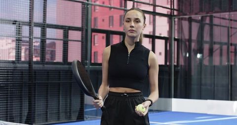 Confident female athlete on padel court wearing sporty attire