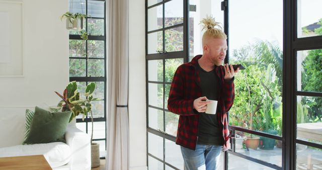 Man by Window with Phone and Coffee in Modern Home - Download Free Stock Images Pikwizard.com