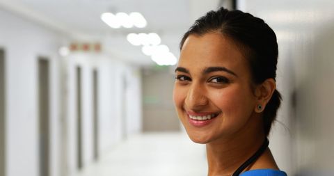 Friendly Female Doctor Smiling in Hospital Corridor