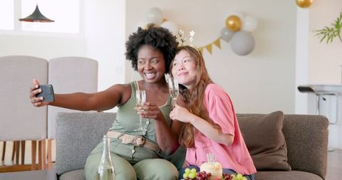 Interracial Lesbian Couple Celebrating Birthday on Couch