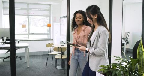 Diversely professional women collaborating in modern office space