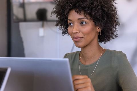 Confident Professional Working with Laptop in Modern Workspace