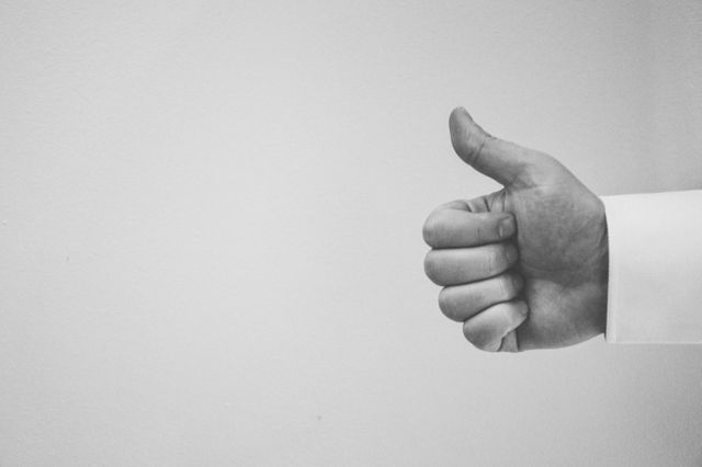Hand giving thumbs up in black and white offers a minimalistic design. Perfect for use in business presentations, and motivational materials, and representing agreement or approval in various visual projects.