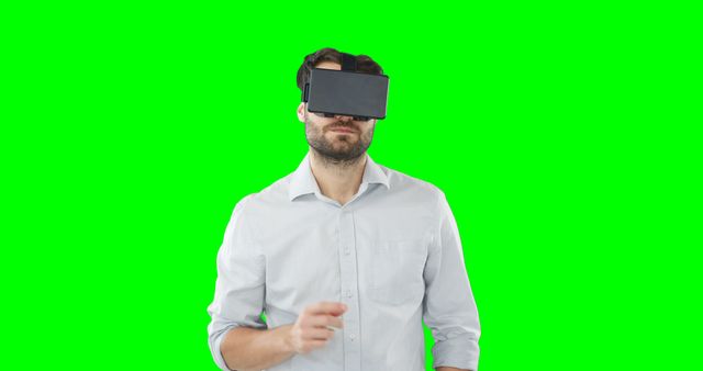 Person wearing VR headset interacting with virtual environment highlighted by green screen background suitable for technology, gaming, and advertising campaigns depicting innovative experiences.