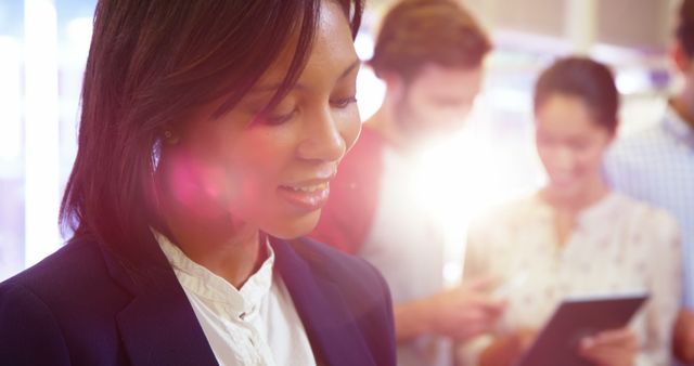 Businesswoman Smiling in Sunlit Office with Colleagues Working - Download Free Stock Images Pikwizard.com