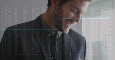 Smiling executive wearing dark suit and tie with digital data overlay by window