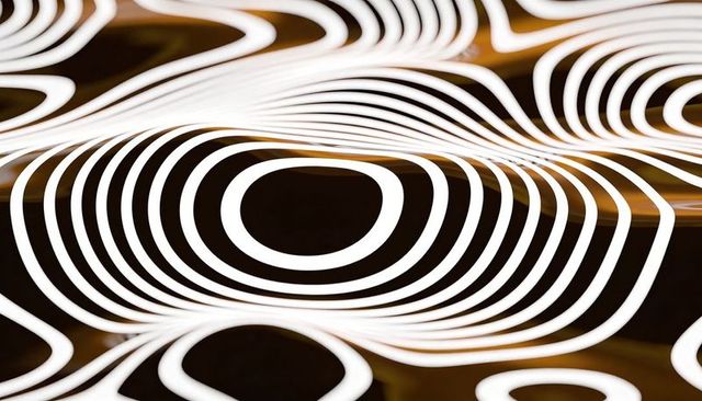 Glowing white concentric rings creating ripple pattern over golden backdrop, abstract art