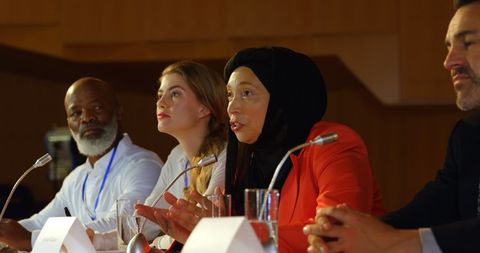 Diverse business panelists engaging in thoughtful discussion at conference