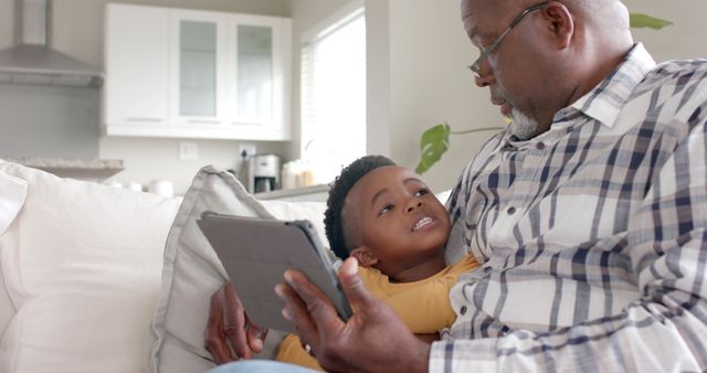 Grandfather Reading Tablet with Grandson on Couch - Download Free Stock Images Pikwizard.com