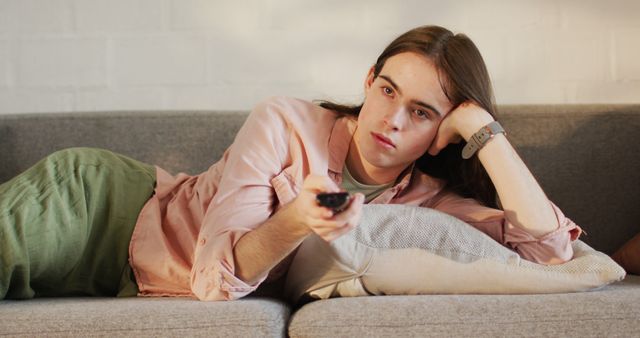 Young Adult Relaxing on Couch Watching Television - Download Free Stock Images Pikwizard.com