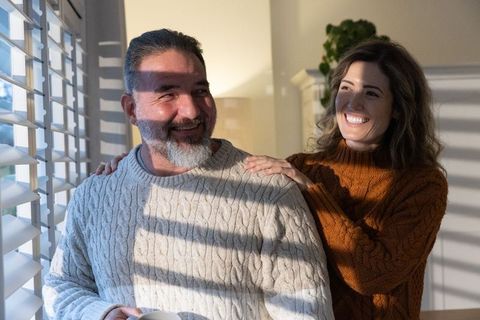 Couple Enjoying Cozy Sunlit Morning by Window Wearing Cable Knit Sweaters