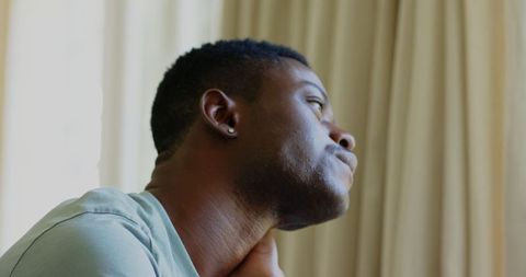 Thoughtful Man Gazing Out Window in Gentle Light
