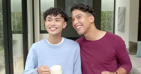 Smiling Friends Relaxing with Coffee in Modern Living Room