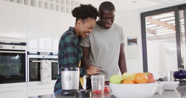 Image of happy african american couple preparing meal together in kitchen. Love, relationship and spending quality time together concept.