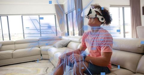 Young man using vr headset at home with holographic interface and immersive digital elements
