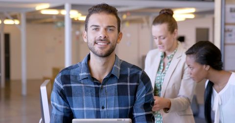Smiling professional in modern office with female colleagues