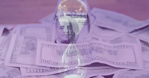 Hourglass timelapse of wealth over stacked cash background