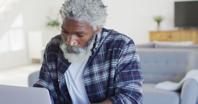 Elderly man working on laptop in cozy home environment - Download Free Stock Images Pikwizard.com