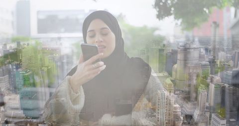 Woman in hijab utilizing smartphone over cityscape background