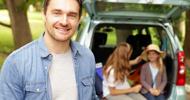 Smiling Man with Family Packing Car for Road Trip Outdoors - Download Free Stock Images Pikwizard.com