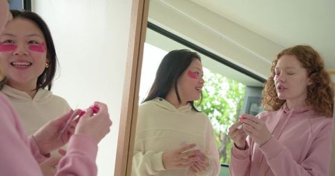 Friends applying under-eye patches and skincare together in casual morning routine