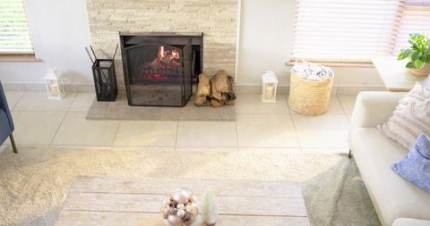 Glowing fireplace warming bright modern living room with neutral decor and cozy accents