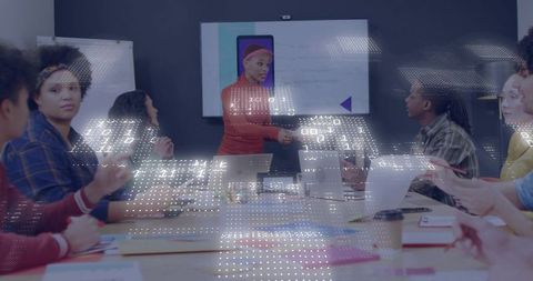 Woman leading mobile app presentation in collaborative boardroom with digital data overlay
