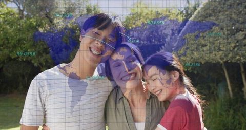 Smiling family hugging in sunlit backyard with world map overlay and digital coordinates