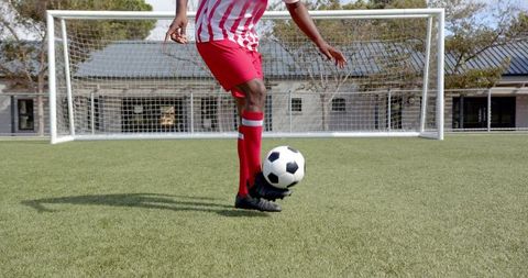 Athlete Dribbling Soccer Ball on Green Turf Field