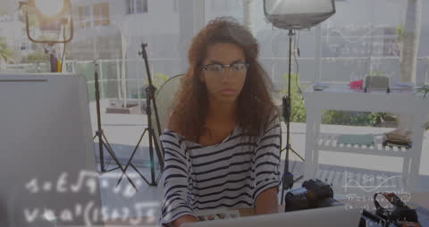 Focused Businesswoman Analyzing Data with Mathematical Equations Overlay