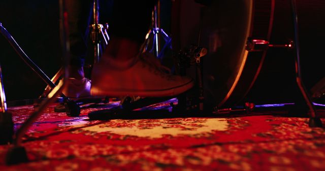 A drummer's feet in motion as they play a drum kit, highlighted by stage lighting, with copy space. Capturing the energy and rhythm of a live music performance, the image conveys the intensity of a concert setting.
