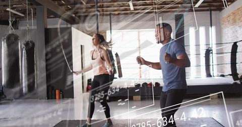 Couple Jumping Rope in Boxing Gym Performing Synchronized Cardio Workout with Tech Overlays