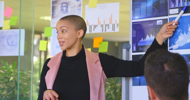 Businesswoman Presenting Data in Modern Office with Glass Walls and Sticky Notes - Download Free Stock Images Pikwizard.com