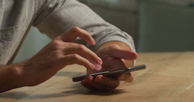 Close-up of hands using smartphone on wooden table - Download Free Stock Images Pikwizard.com